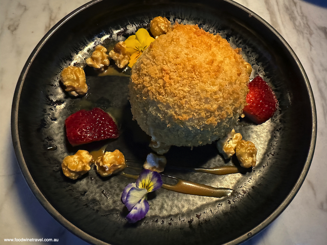 Fried pandan icecream garnished with caramelised popcorn, toffee sauce and dainty pansies.